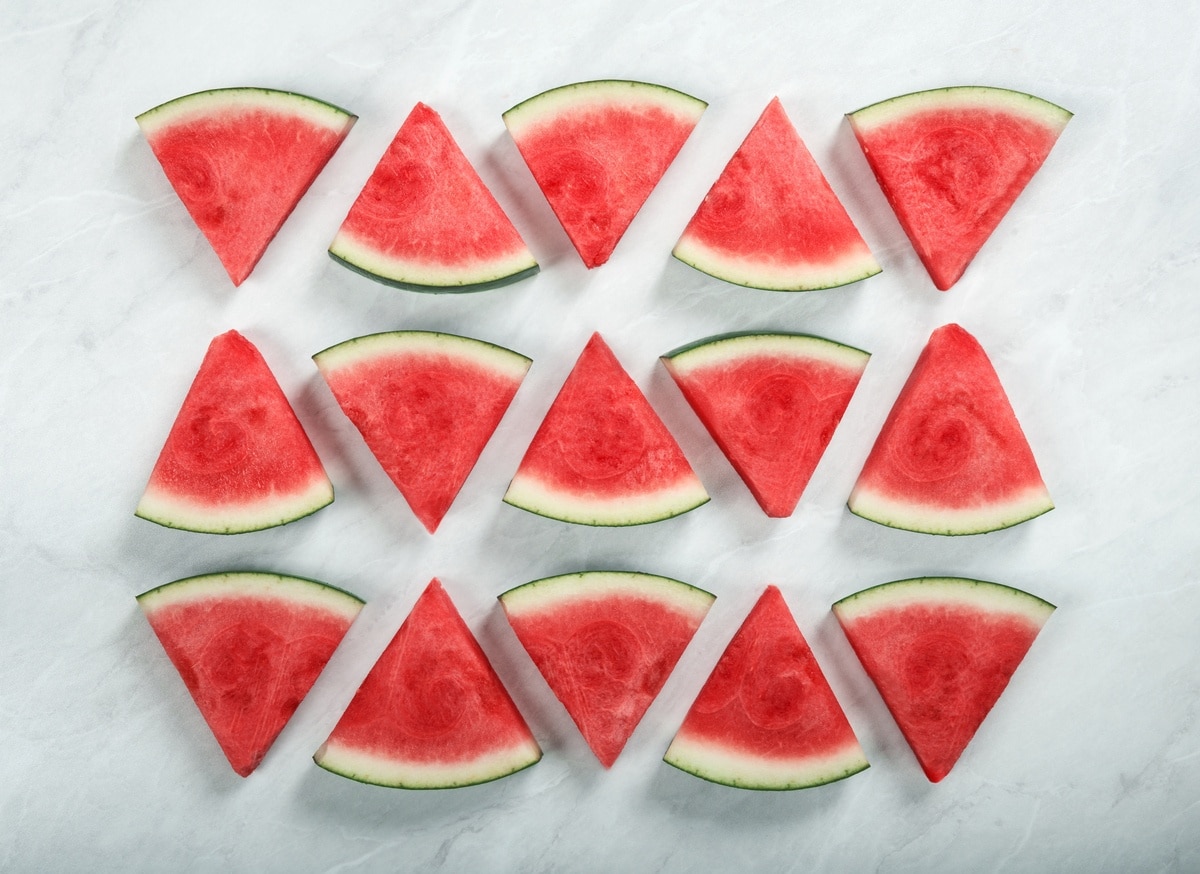 triangle shaped slices of watermelon, arranged in three rows of five
